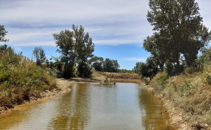 Blick auf ein Gewässer auf dem eine Messstelle aufgebaut wird